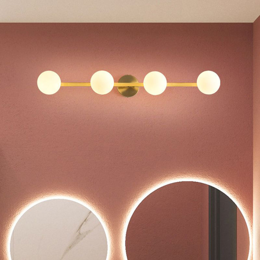 Sevra four globe wall light lit on a terracotta bathroom wall
