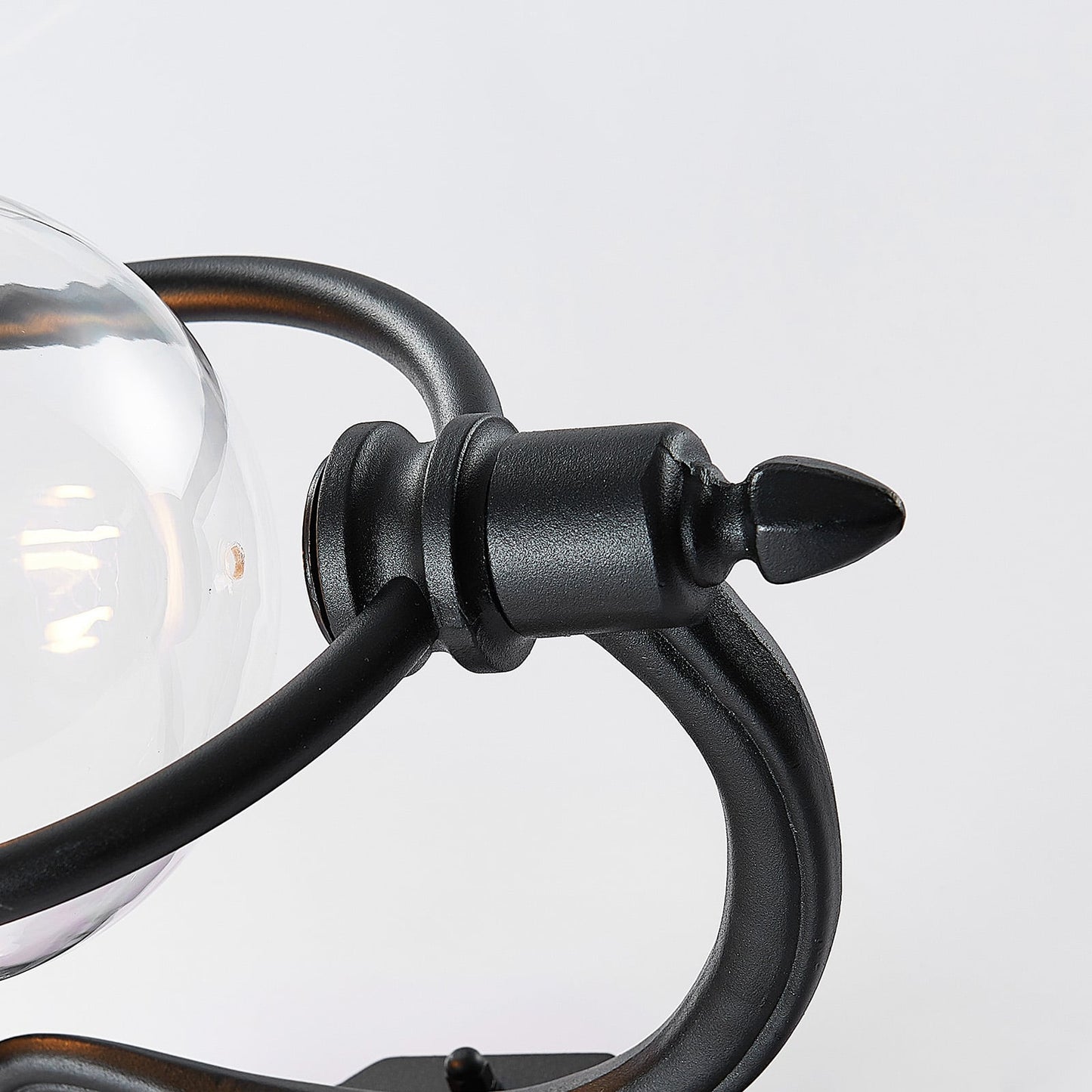 Close detail of the Koma black cast bracket arm and clear glass bowl