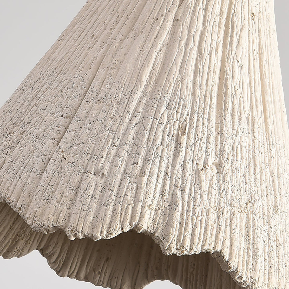 Detail of the ribbed microcement surface and torn scalloped rim of the Plavo shade