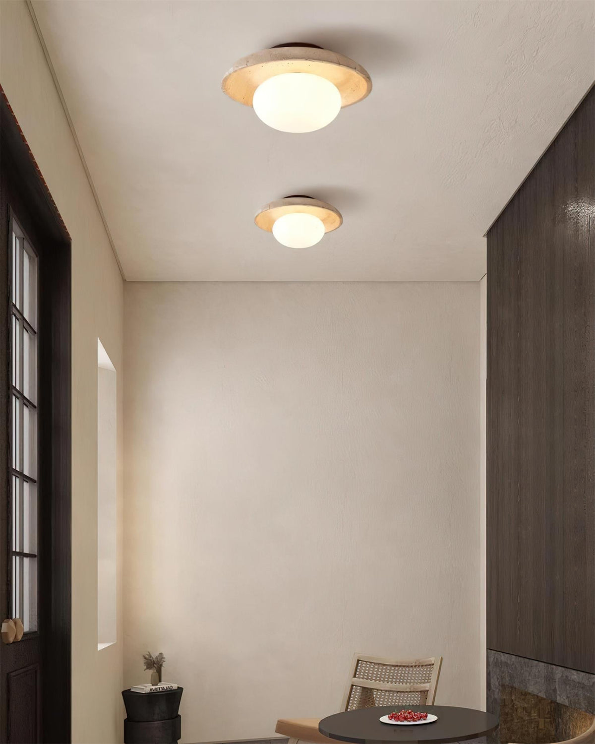 Two Renvo travertine ceiling lights lighting a neutral room with a window
