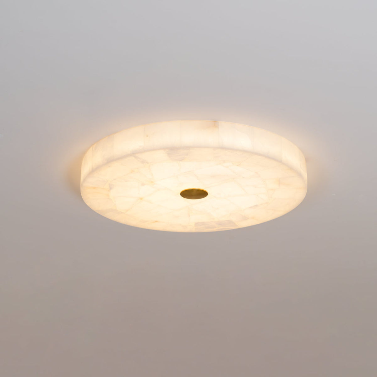 Cirra round alabaster ceiling light 3/4 angle view warm ambient light
