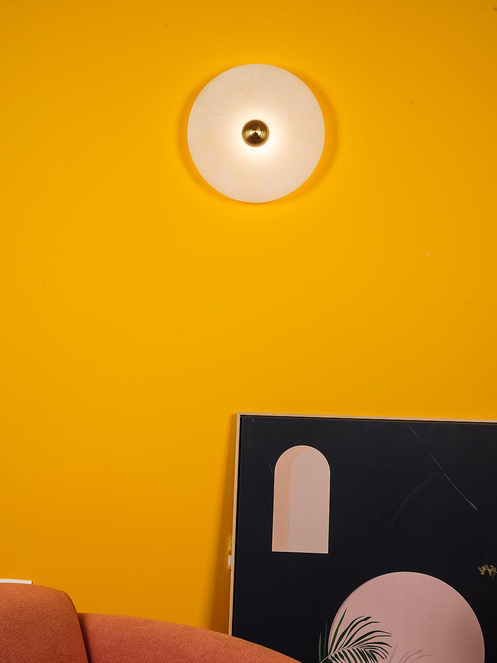 Corven single alabaster disc sconce on yellow accent wall