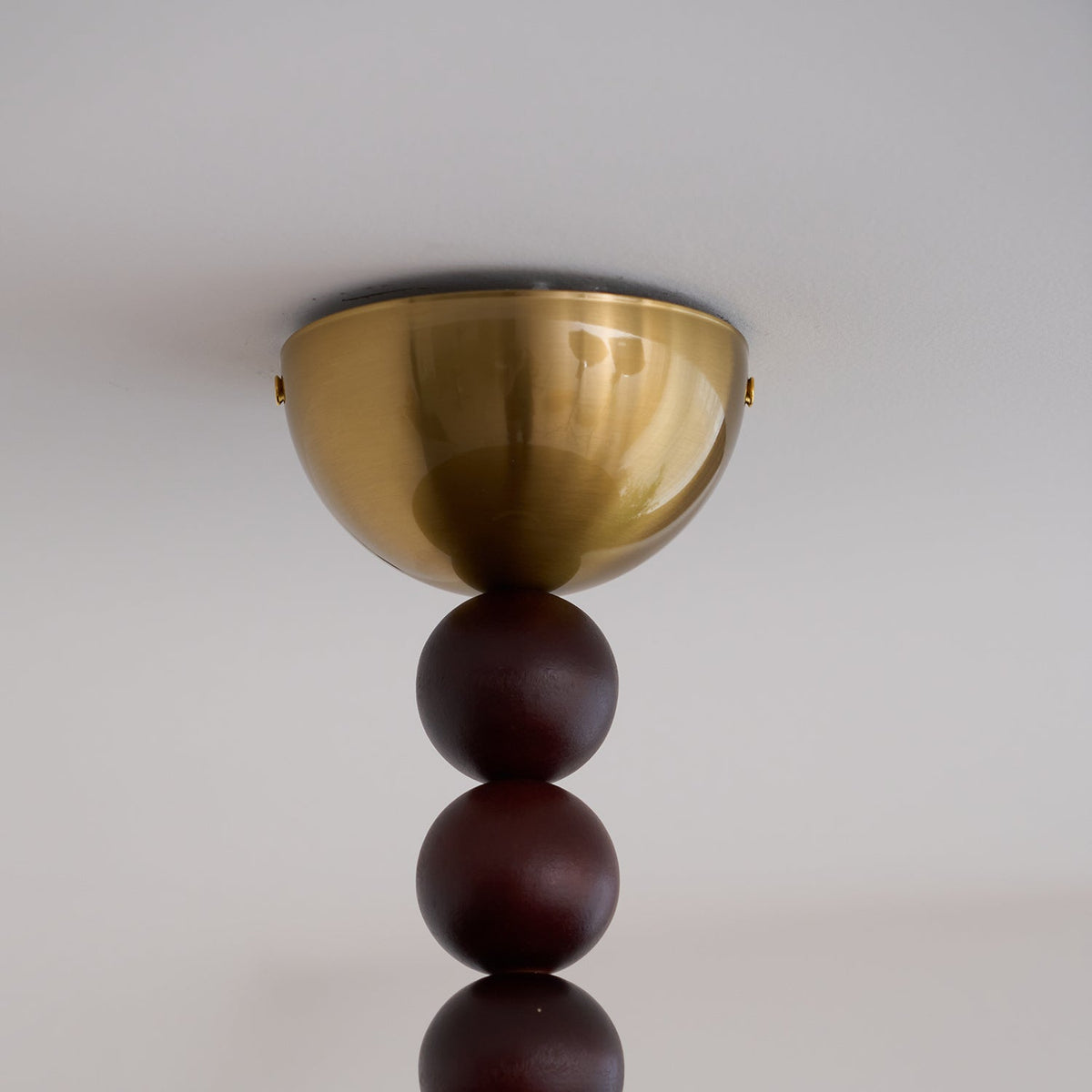 Close view of the brass canopy and turned walnut beads on the Walo Walnut Alabaster Effect Ceiling Light