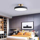 Nelo black flush mount ceiling light in a modern bedroom with grey panel wall