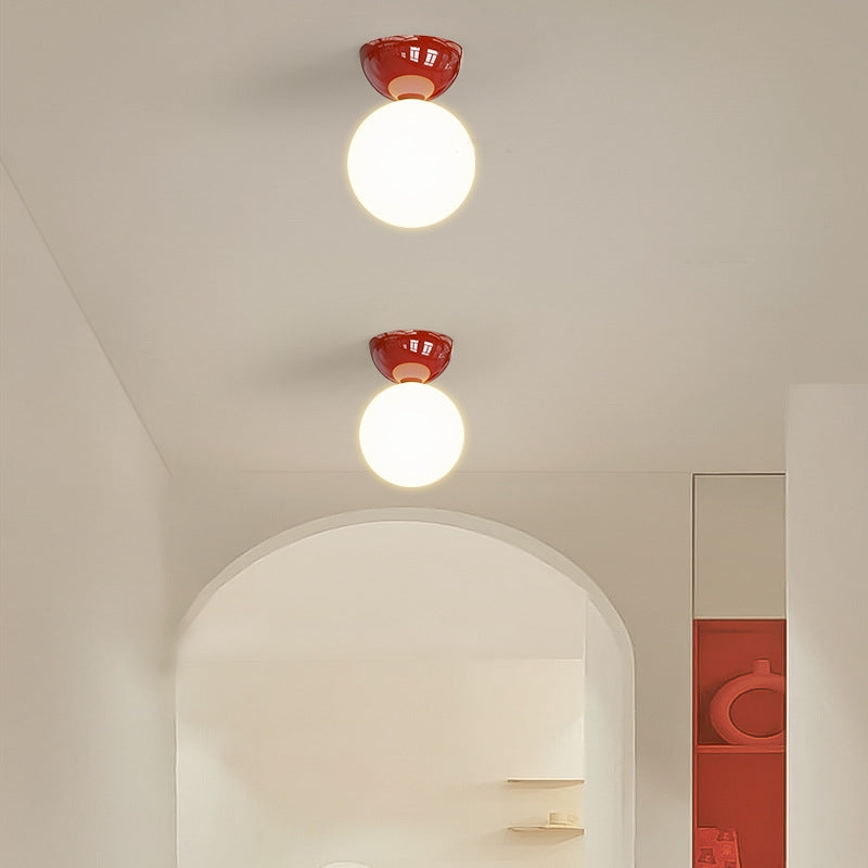 Two red Vellona Petite ceiling lights fitted along a bright hallway ceiling