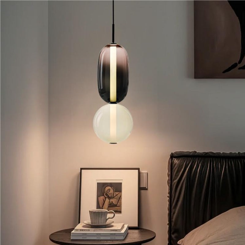 Ambero pendant light hanging beside a bed over a small round bedside table
