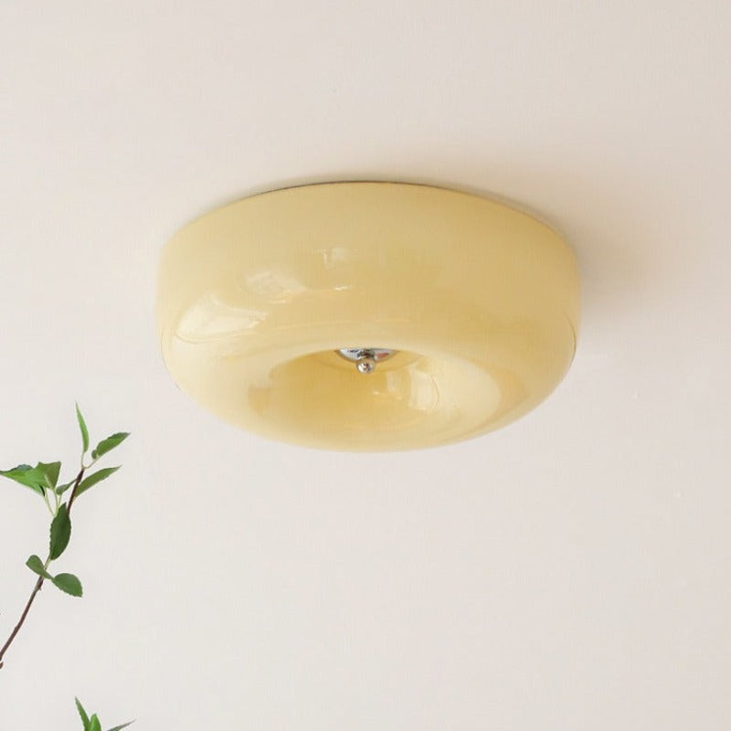 Cando Cream Glass Ceiling Light with a trailing green plant in the foreground