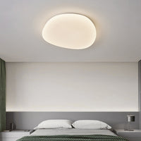 Sayen flush mount ceiling light above a bed in a neutral bedroom