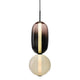 Ambero amber glass pendant light on a white background, smoked amber oval shade above an opal glass globe