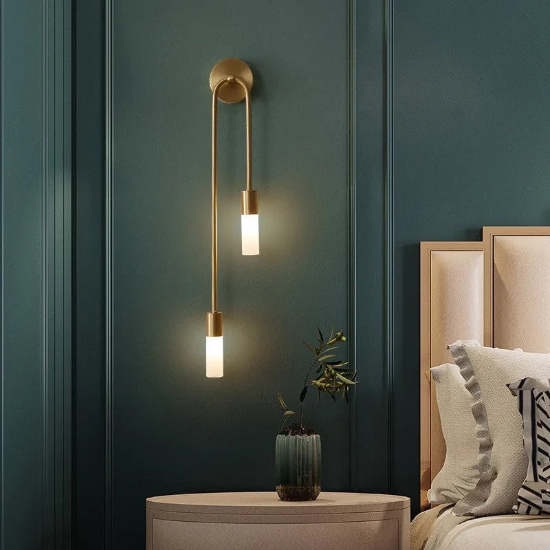 Vano gold wall sconce beside bed in teal bedroom