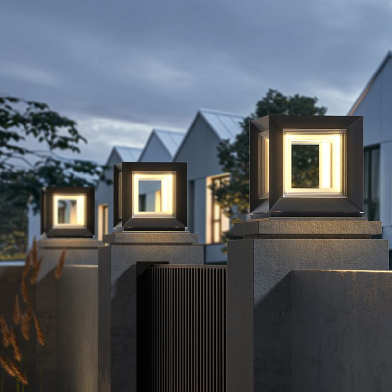 Three Dravo cube pillar lights lit along a row of concrete piers at a house entrance