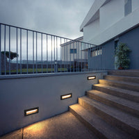 Palo step lights installed in rendered garden staircase wall at dusk