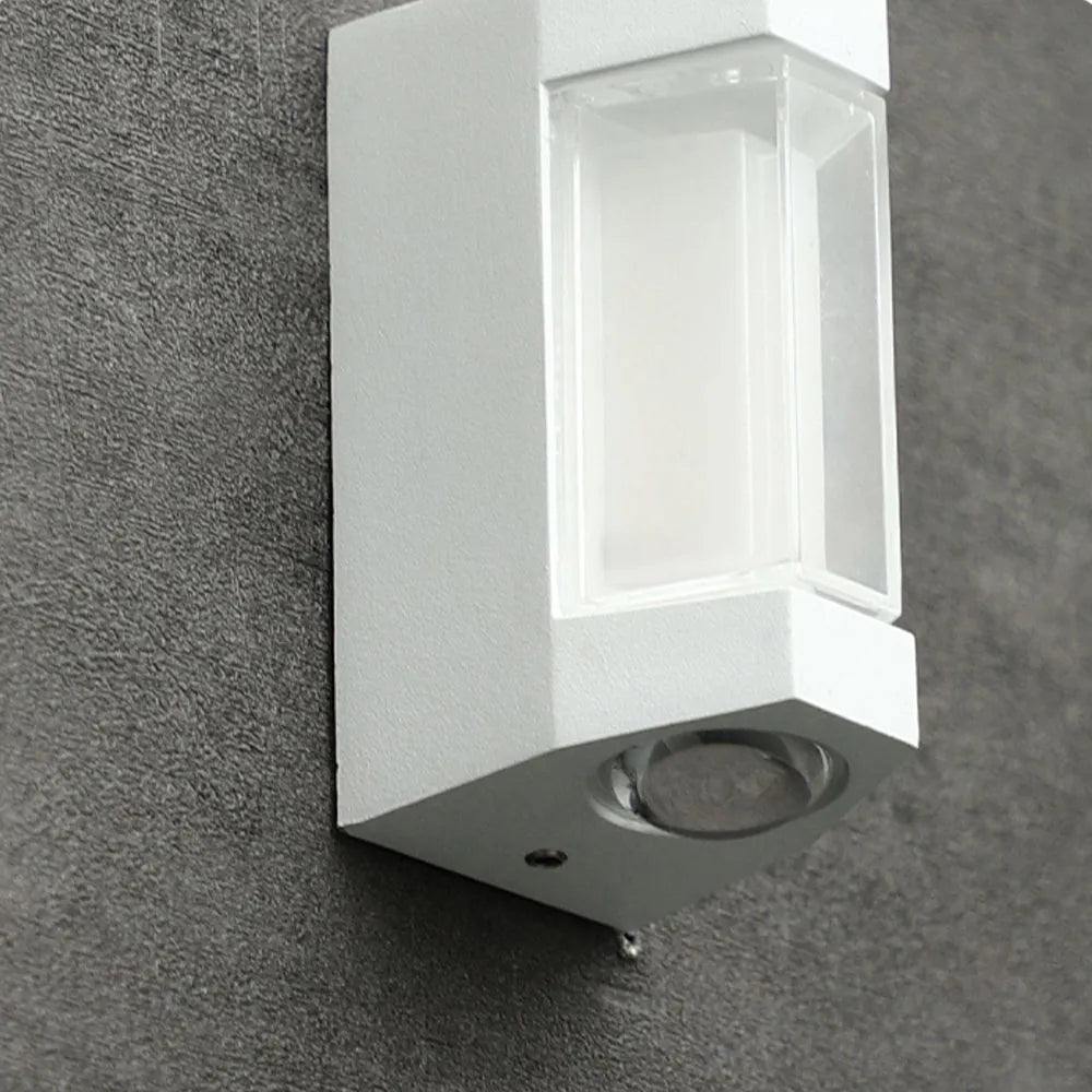 Close view of the white Marvo outdoor wall light on a concrete wall showing the clear lens box and round base lens