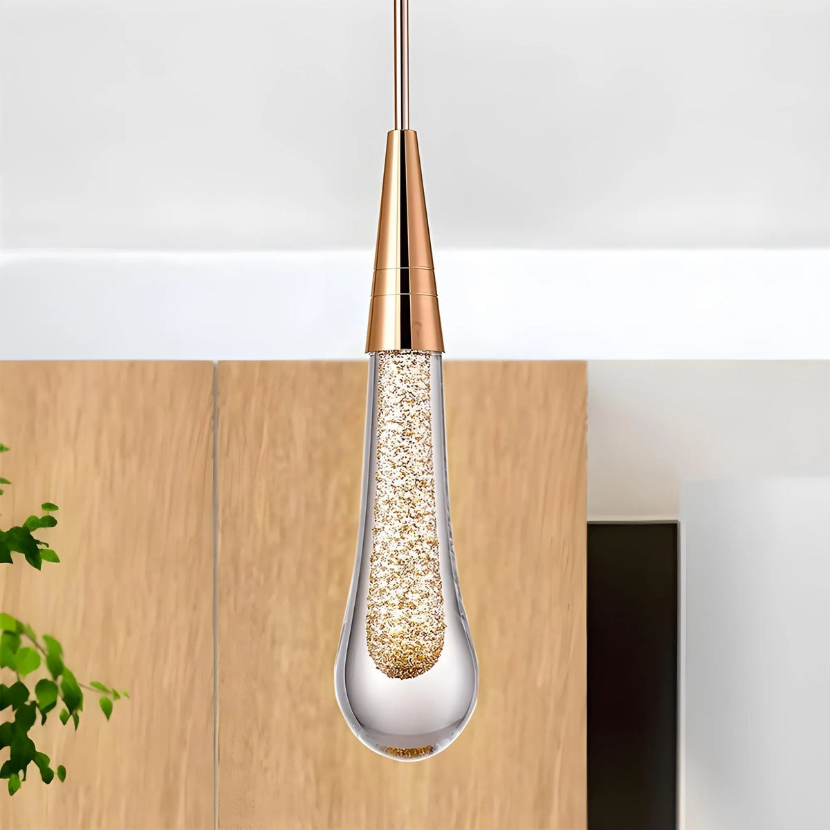 Golvara Teardrop Pendant Light hanging beside a pale oak panel, gold cone and gold-flecked crystal drop
