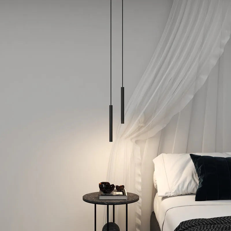 Filon Slim Linear Pendant Light hanging beside a bed next to sheer curtains