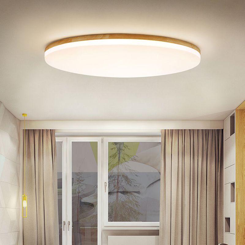 Nolla wood ceiling light lit warm white on a white ceiling above a garden door