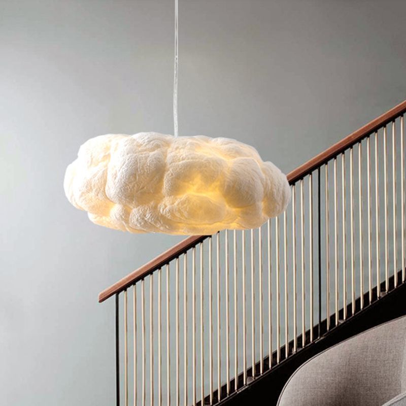 Nuvo cloud pendant light hanging beside a staircase, soft cotton cloud glowing against a pale wall