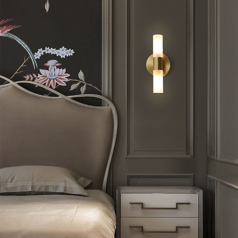 Brenlo brass wall light beside a bed casting light up and down the panelled wall