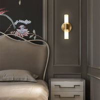 Brenlo brass wall light beside a bed casting light up and down the panelled wall