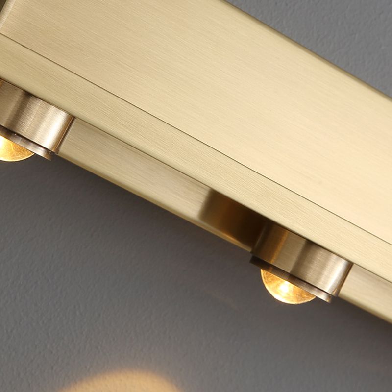 Close up of the brushed brass bar and rounded spotlight housings on the Nolvo wall light
