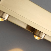 Close up of the brushed brass bar and rounded spotlight housings on the Nolvo wall light