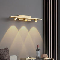 Angled view of the Nolvo brass wall light lit above a living room side table