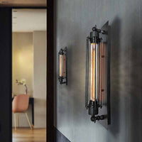 Two Trono cylinder wall lights mounted on a dark grey plaster wall in a hallway