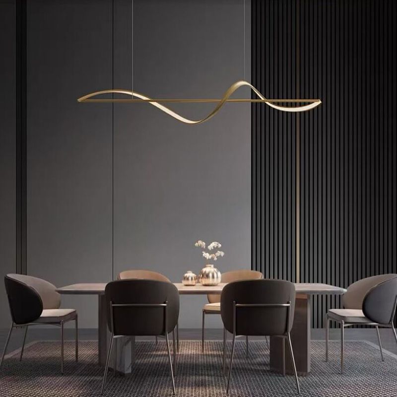 Kavro gold wave pendant light above a long dining table in a dark panelled room
