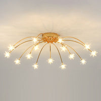 Nevaro gold starburst ceiling light lit, showing fifteen glass stars glowing warm white