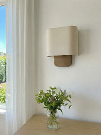 Lino Curved Linen Wall Light unlit beside a window with sheer curtains and fresh flowers