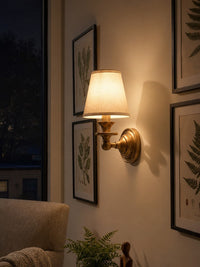 Ruva fabric shade wall light lit in the evening showing the warm glow through the white shade