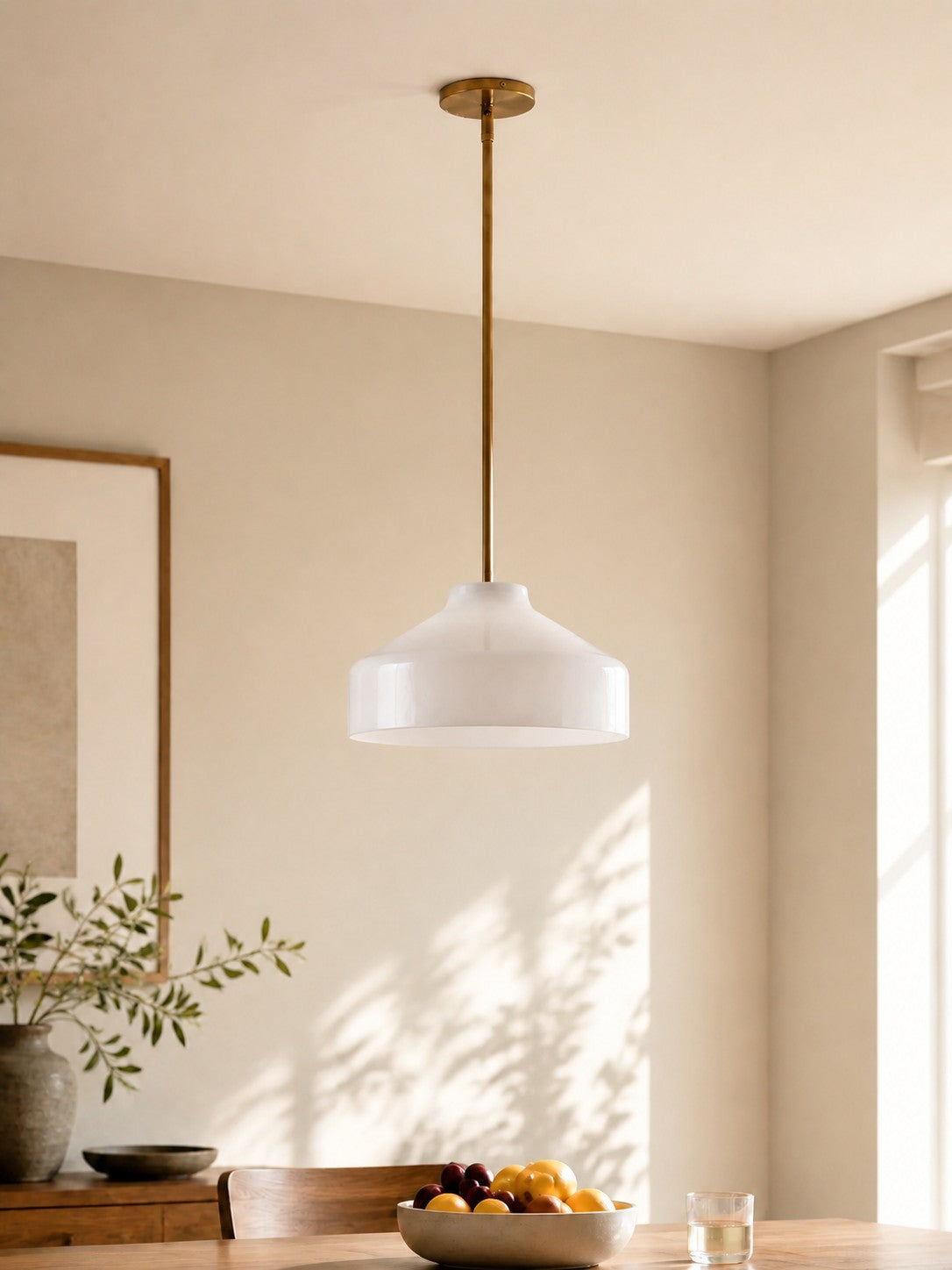 Hano ivory pendant light hanging over a dining table in daylight
