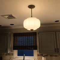 Elva milk glass ceiling light lit in the evening above a kitchen sink