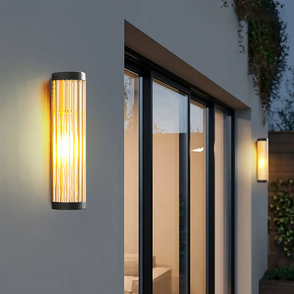 Yoro outdoor wall light beside a glazed door, showing the ribbed glass tube and black end caps