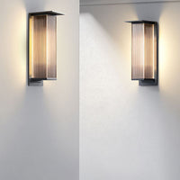 Pair of Rekta wall lights lit on adjoining white walls
