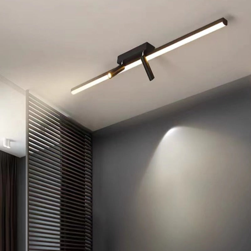 Vixa black LED ceiling bar fitted flush to a white ceiling with one spot head angled down a dark slatted wall