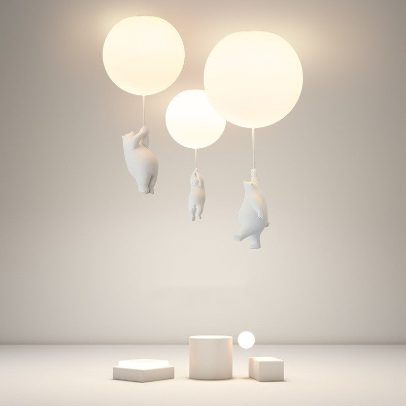 Wisto bear and balloon cluster ceiling light lit in a plain studio room, showing the warm glow of the three shades