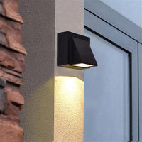 Vosto Slim Outdoor Wall Light fitted to a rendered pillar beside a window, lighting the wall below