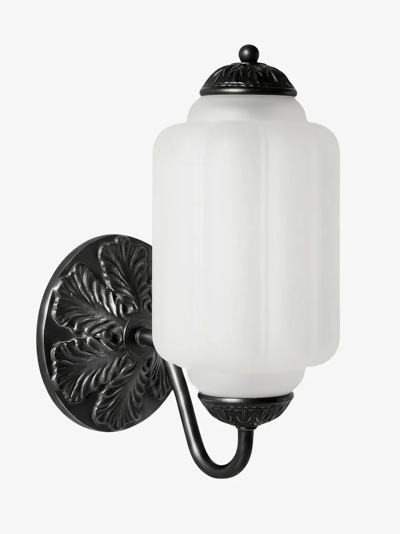 Elva milk glass wall sconce shown from an angle on a plain background