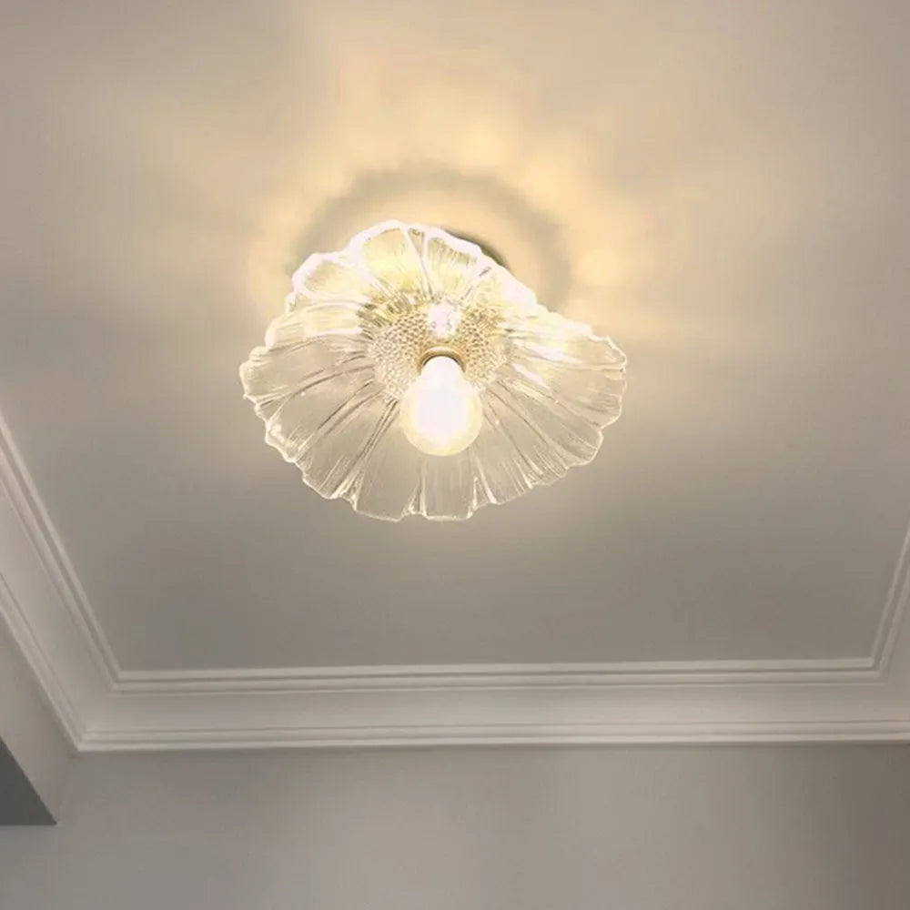 Calo petal glass ceiling light lit against a ceiling with plaster cornice
