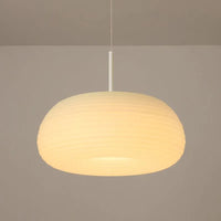 Ombia pendant lit on the warm colour setting against a taupe wall