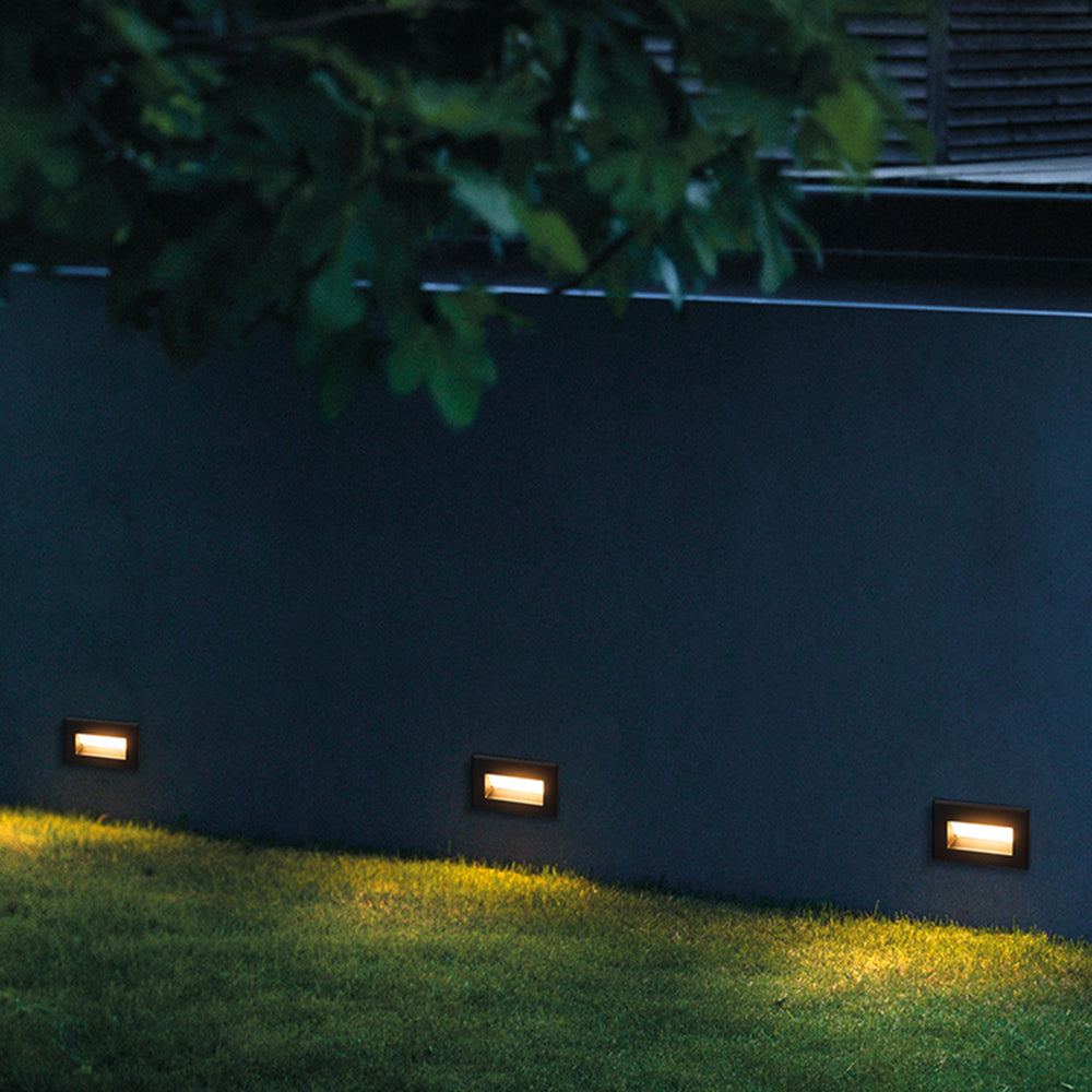 Palo step lights mounted at ground level in rendered garden boundary wall