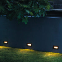 Palo step lights mounted at ground level in rendered garden boundary wall