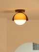 Suno sunset ceiling light with amber dome and opal globe against a plain warm wall