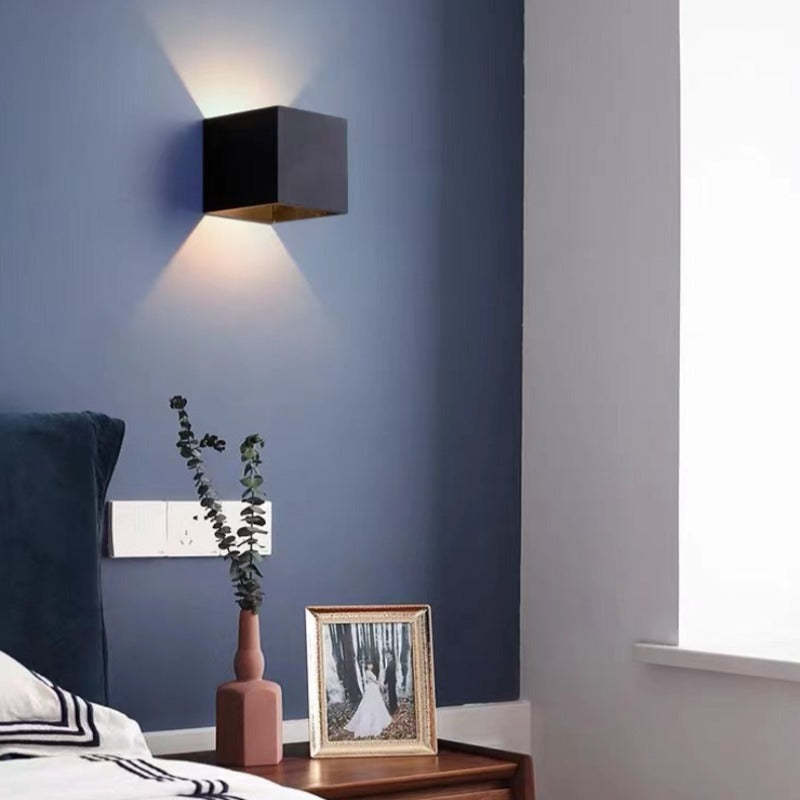Nexo black wall light casting up and down light on a blue bedroom wall