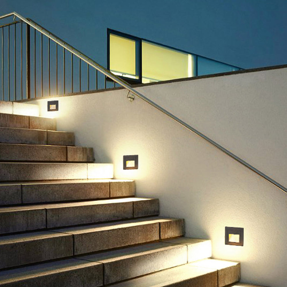 Steva square step lights set into a stair wall at dusk, marking each tread with warm light