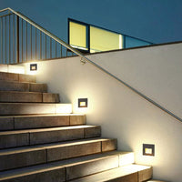 Steva square step lights set into a stair wall at dusk, marking each tread with warm light