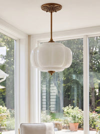 Elva milk glass ceiling light hanging in a bright garden room