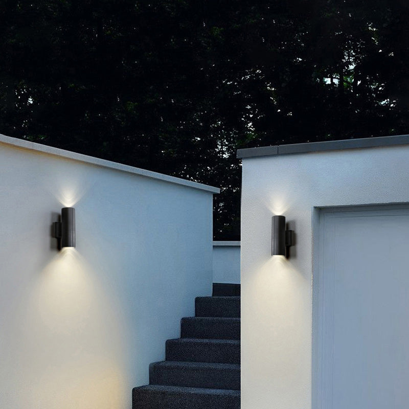 Two Belvo twin-head wall lights on white exterior walls at night lighting a flight of steps