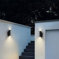 Two Belvo twin-head wall lights on white exterior walls at night lighting a flight of steps